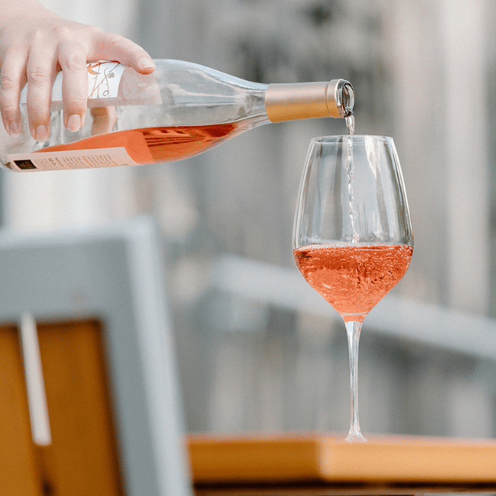 Glass of rosé wine being poured